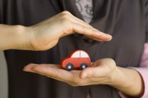 Hands holding small red car