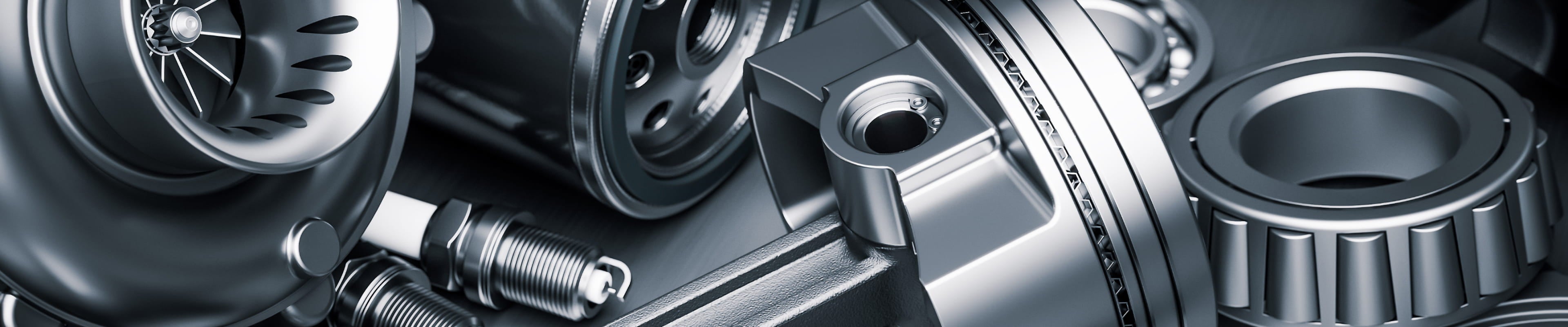 Close-up of automotive engine components including a turbocharger, brake rotor, and bearings.